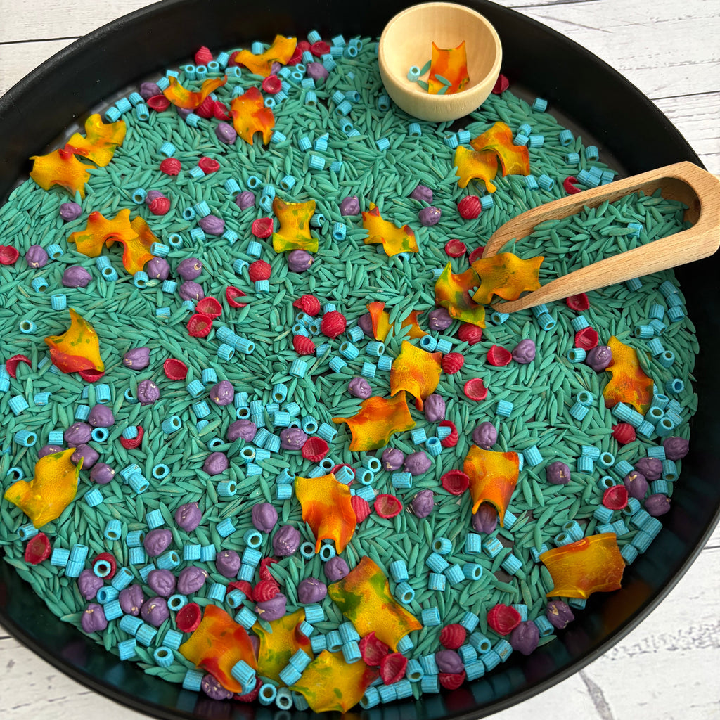 Colorful sensory bin with toys on a wooden surface